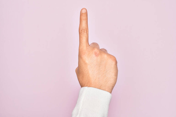 Рука кавказького молодого чоловіка, який показує пальці над ізольованим рожевим тлом, підраховуючи номер один, використовуючи індексний палець, показуючи ідею та розуміння
 - Фото, зображення