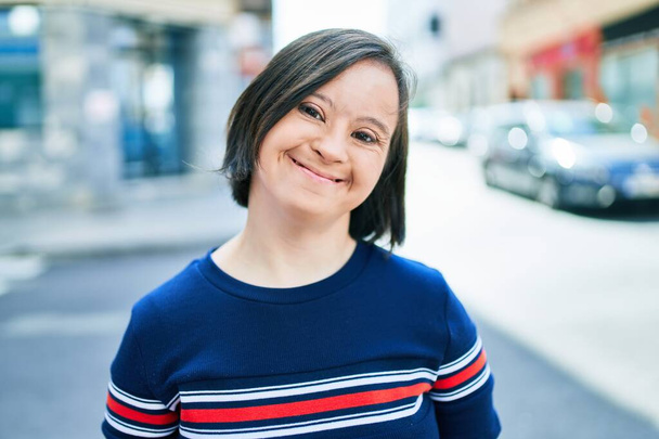 Beautiful brunette woman with down syndrome at the town on a sunny day - Fotó, kép
