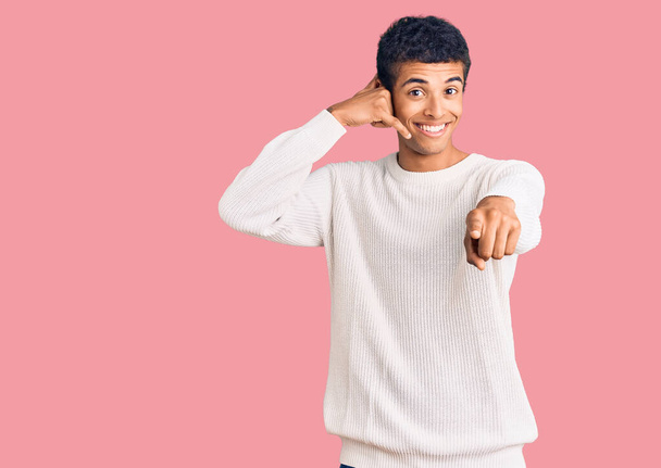 Νεαρός Αφροαμερικάνος που φοράει καθημερινά ρούχα χαμογελώντας να μιλάει στην τηλεφωνική χειρονομία και να δείχνει εσένα. Τηλεφώνησέ μου..  - Φωτογραφία, εικόνα