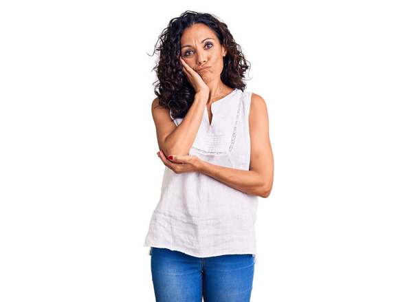 Μέση ηλικία όμορφη γυναίκα φορώντας casual αμάνικο t πουκάμισο σκέψης φαίνεται κουρασμένος και βαρεθεί με προβλήματα κατάθλιψης με σταυρωμένα χέρια.  - Φωτογραφία, εικόνα