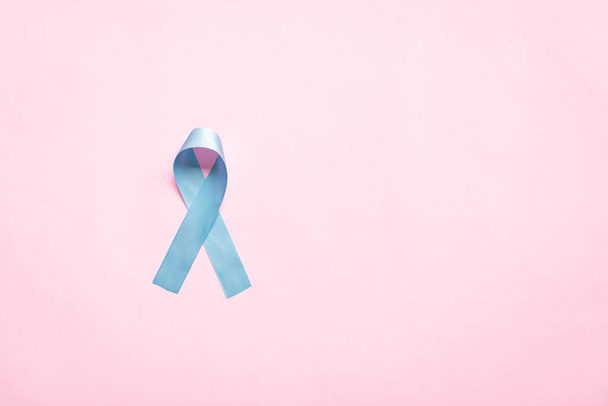 November light blue ribbon on pink background with copy space, Prostate cancer awareness month, men's health concept - Photo, Image