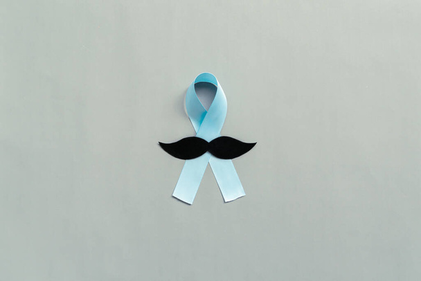 Novembro fita azul claro com bigode no fundo cinza com espaço de cópia, mês de consciência do câncer de próstata, conceito de saúde dos homens - Foto, Imagem