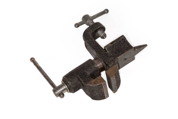 Old home bench vise with small anvil on the back and fastening to the workbench with screw clamp, view from jaws side on a white background - Photo, Image