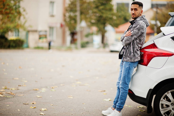 Student kuwaiti man wear at hoodie stand near car. - Фото, изображение
