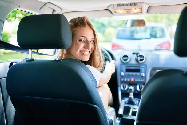 Nuori kaunis blondi nainen hymyilee onnellinen ajo-auto - Valokuva, kuva