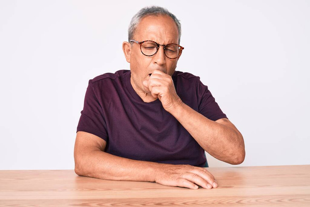 Senior handsome man with gray hair wearing casual clothes and glasses feeling unwell and coughing as symptom for cold or bronchitis. health care concept.  - Fotoğraf, Görsel