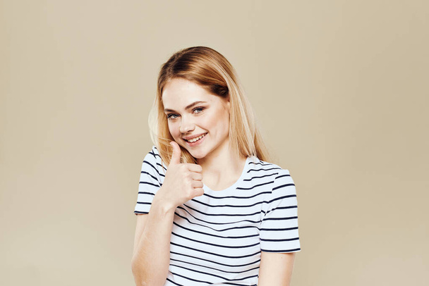 Cute blonde striped t-shirt smile lifestyle beige studio background - Fotoğraf, Görsel