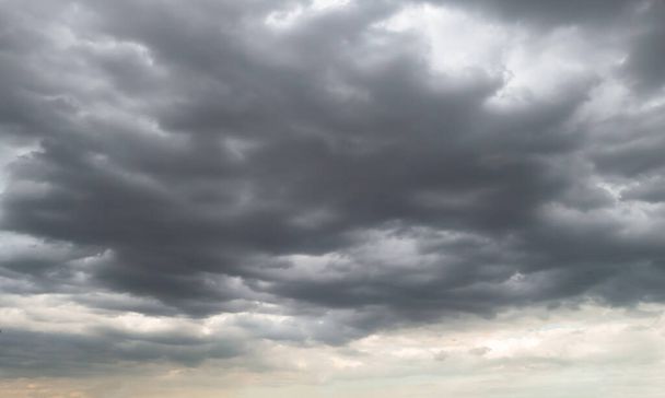 Donkere storm wolken voor regen gebruikt voor klimaat achtergrond. Wolken worden donker grijs voordat het regent. Abstracte dramatische achtergrond. - Foto, afbeelding