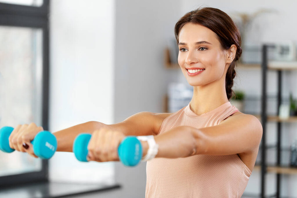 happy woman with dumbbells exercising at home - Foto, Imagen