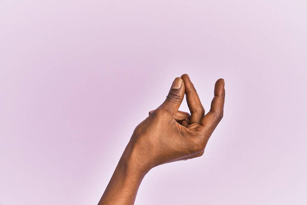Brazo y mano de mujer negra de mediana edad sobre fondo aislado rosa chasquidos dedos para el éxito, fácil y haga clic en gesto símbolo con la mano  - Foto, imagen