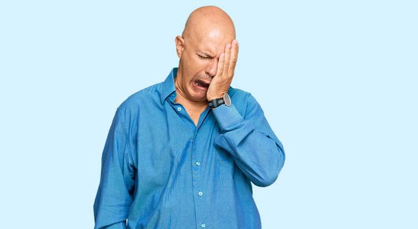 Middle age bald man wearing casual clothes yawning tired covering half face, eye and mouth with hand. face hurts in pain.  - Photo, Image