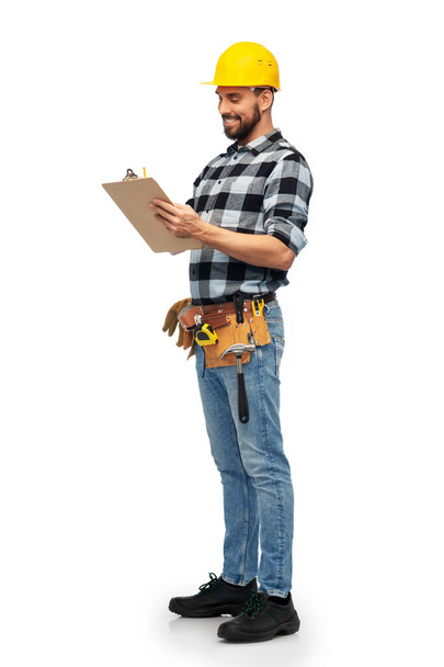 male worker or builder in helmet with clipboard - Fotó, kép