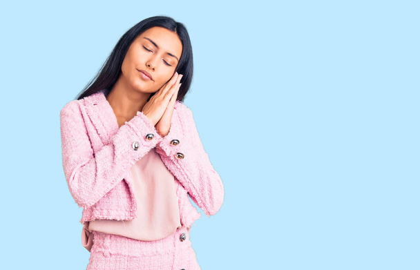 Νεαρή όμορφη Λατίνα κοπέλα που φοράει επαγγελματικά ρούχα κοιμάται κουρασμένη ονειρεύεται και ποζάρει με τα χέρια μαζί χαμογελώντας με κλειστά μάτια.  - Φωτογραφία, εικόνα