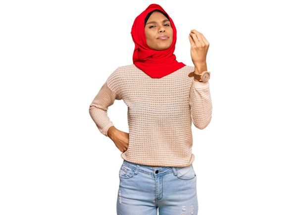 Mujer afroamericana joven que usa bufanda islámica tradicional del hiyab que hace el gesto italiano con la mano y los dedos expresión confiada  - Foto, Imagen