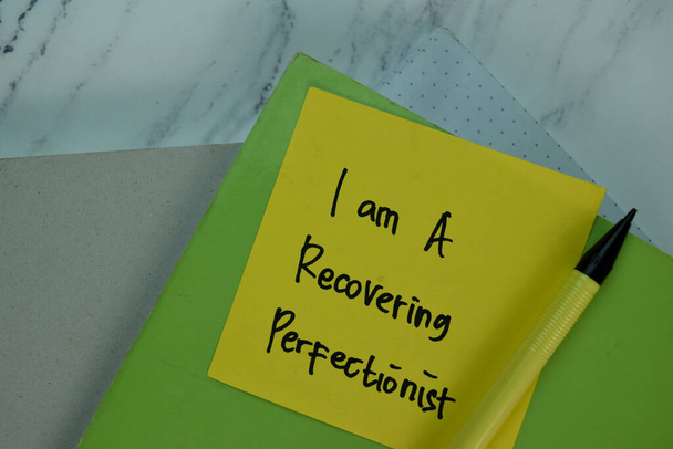 I am a Recovering Perfectionist write on sticky note isolated on Wooden Table. - Photo, Image