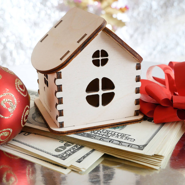 wooden house model, gold chocolate coins and new year decorations on shining background with copy space, xmas background, Welth concept. New year sales for new houses concept - Photo, Image