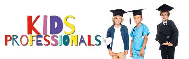 children in graduation caps dressed in costumes of different professions near kids professionals lettering on white, banner - Foto, Imagen
