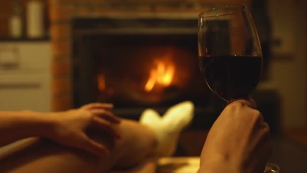 Elinde kırmızı şarap olan kadın şöminenin yanında dinleniyor.. - Video, Çekim