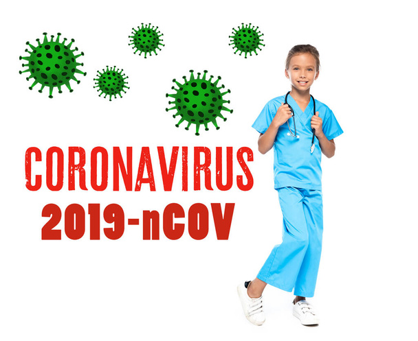 child in costume of doctor touching stethoscope near coronavirus 2019-nCov lettering on white  - Фото, изображение