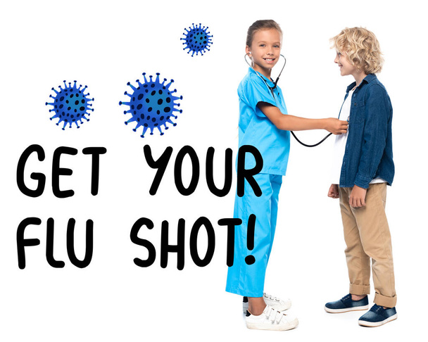 niño disfrazado de médico examinando chico rubio y rizado cerca de conseguir sus letras de la vacuna contra la gripe en blanco  - Foto, imagen