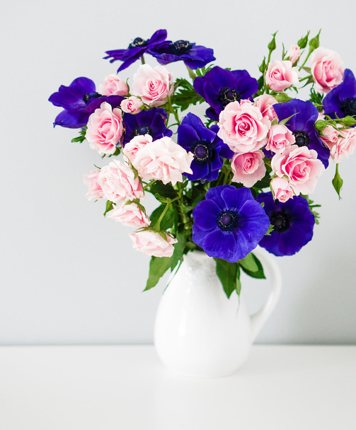 Bouquet of pink roses and blue anemones in white vase - Foto, Imagem