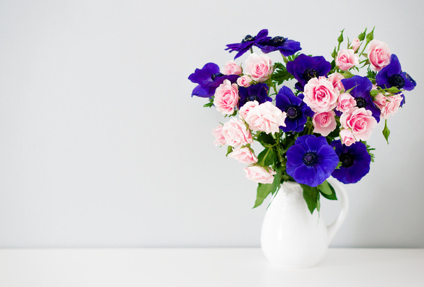 Bouquet of pink roses and blue anemones in white vase - Foto, afbeelding