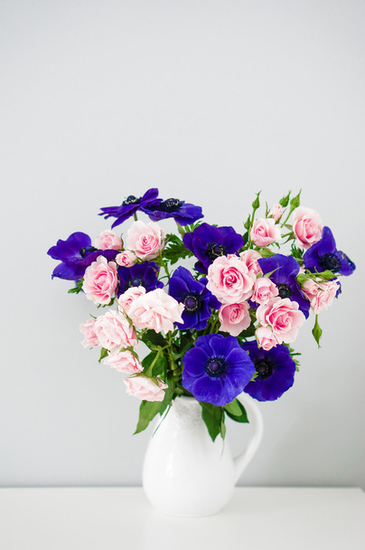 Bouquet of pink roses and blue anemones in white vase - Foto, Imagen
