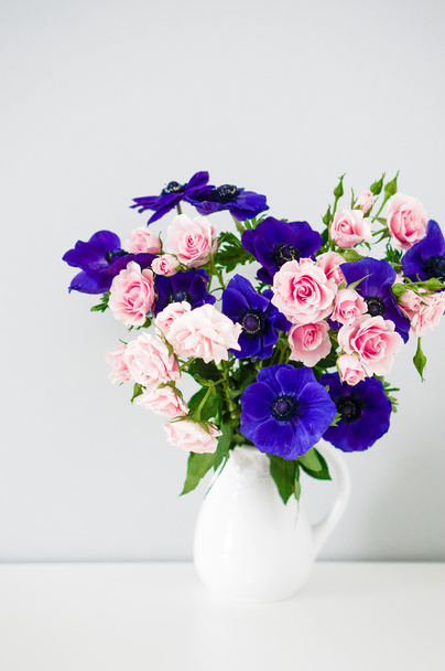Bouquet of pink roses and blue anemones in white vase - Фото, зображення