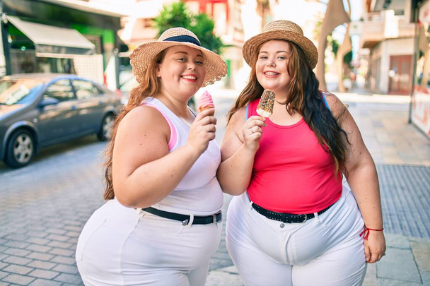 Dvě plus velikost nadváha sestry dvojčata ženy usmívají jíst zmrzlinu venku - Fotografie, Obrázek
