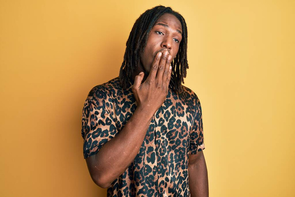 African american man with braids wearing leopard animal print shirt bored yawning tired covering mouth with hand. restless and sleepiness.  - Fotografie, Obrázek