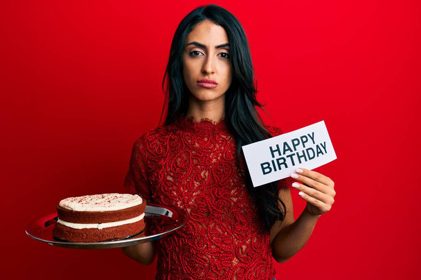 Beautiful hispanic woman celebrating birthday with cake skeptic and nervous, frowning upset because of problem. negative person.  - Valokuva, kuva