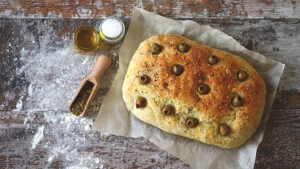 Fresh homemade focaccia with italian herbs. Cooking at home. Traditional italian bread with olives. - Zdjęcie, obraz