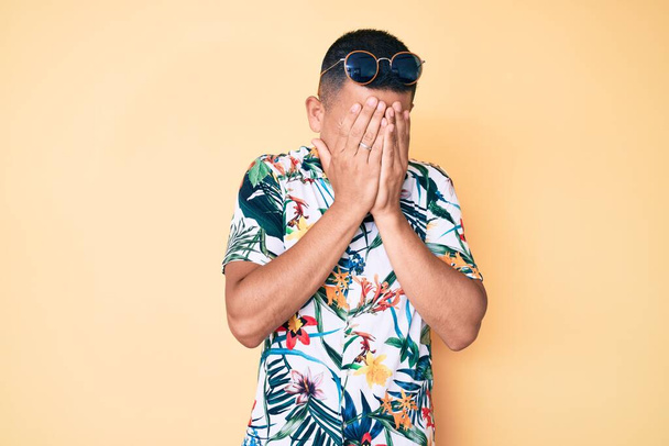 Young handsome latin man wearing summer clothes with sad expression covering face with hands while crying. depression concept.  - Foto, afbeelding