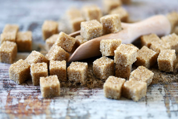 Ζάχαρη από ζαχαροκάλαμο σε ξύλινη σπάτουλα. - Φωτογραφία, εικόνα