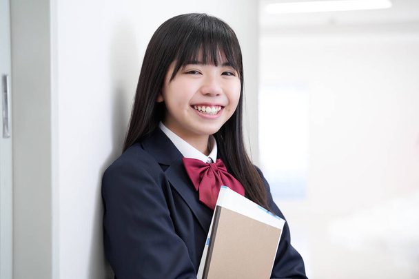 Uma menina japonesa do ensino médio júnior fica no corredor de sua escola - Foto, Imagem