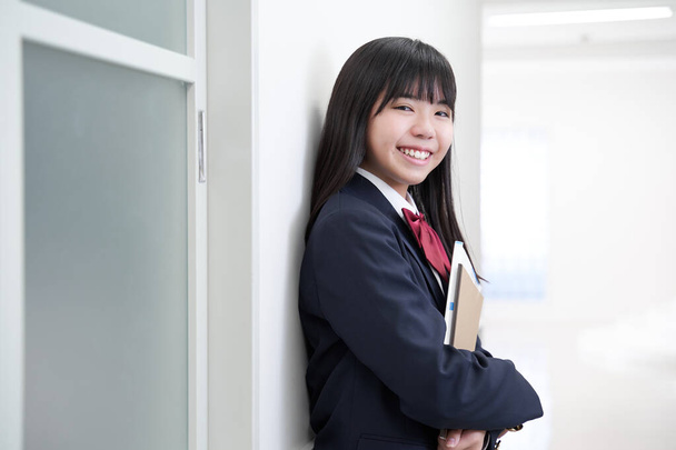 Uma menina japonesa do ensino médio júnior fica no corredor de sua escola - Foto, Imagem