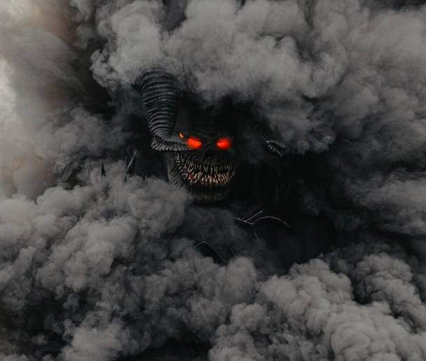 Mutant krijger staat met gloeiende ogen tegen een achtergrond van zwarte rook. - Foto, afbeelding