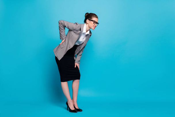 Full length body size view of classy sick businesslady teacher feeling bad leaning touching sick back isolated bright blue color background - Foto, afbeelding