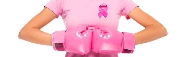 Vista recortada de la mujer en guantes de boxeo y cinta rosa de conciencia de cáncer de mama aislado en blanco, bandera - Foto, Imagen