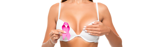 Cropped view of young woman in bra holding ribbon of breast cancer awareness isolated on white, banner  - Фото, изображение