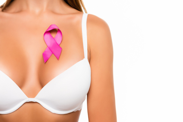 Ausgeschnittene Ansicht von rosa Zeichen von Brustkrebs Bewusstsein auf der Brust der Frau in BH isoliert auf weiß - Foto, Bild