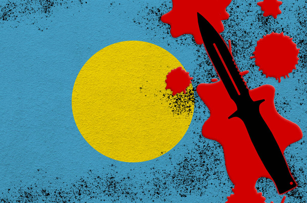 Palau-Flagge und schwarzes taktisches Messer in rotem Blut. Konzept für Terroranschläge oder Militäroperationen mit tödlichem Ausgang. Gefährlicher Einsatz von Nahkampfwaffen - Foto, Bild