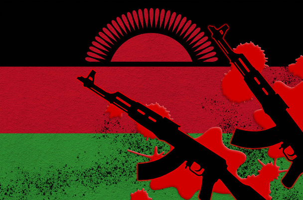 Flaga Malawi i dwa czarne karabiny AK-47 w czerwonej krwi. Koncepcja ataku terrorystycznego lub operacji wojskowych ze skutkiem śmiertelnym. Niebezpieczne użycie broni - Zdjęcie, obraz