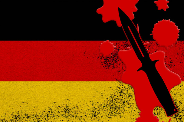 Saksan lippu ja musta taktinen veitsi punaisella verellä. Ajatus terrori-iskusta tai tappavista sotilasoperaatioista. Vaarallinen melee aseiden käyttö - Valokuva, kuva