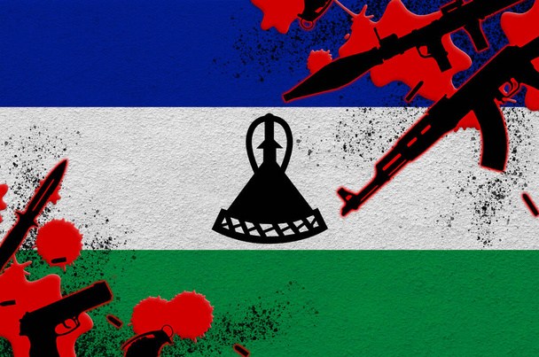 Lesotho zászló és különböző fegyverek vörös vérrel. Terrortámadás és halálos kimenetelű katonai műveletek koncepciója. Fegyverkereskedelem - Fotó, kép