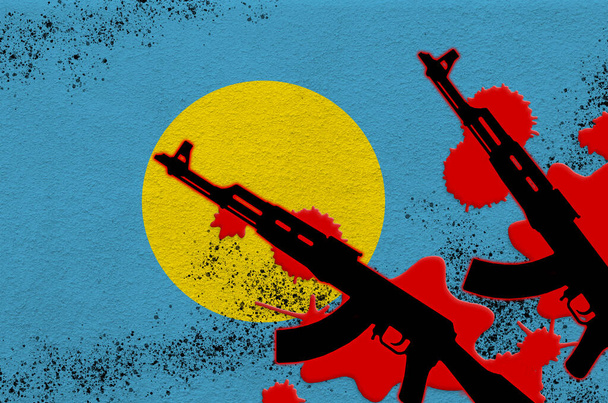 Bandeira de Palau e dois fuzis AK-47 pretos a sangue vermelho. Conceito para ataque terrorista ou operações militares com resultado letal. Uso de armas perigosas - Foto, Imagem