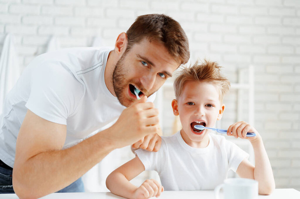 Dad and little son brushing teeth together - Foto, Imagen