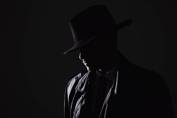 Old fashioned detective in hat on dark background - Photo, Image