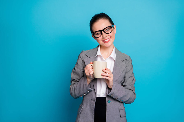 Portrait of positive ceo worker assistant hold aromatic latte wear grey suit blazer jacket isolated blue color background - Zdjęcie, obraz