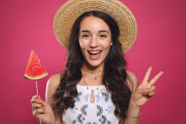 Beautiful young woman with watermelon on pink background - 写真・画像